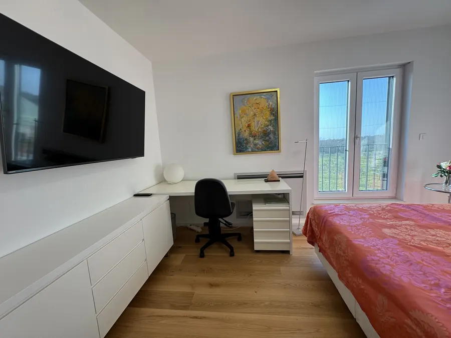 Zimmer mit Fernseher, Schreibtisch und Bett